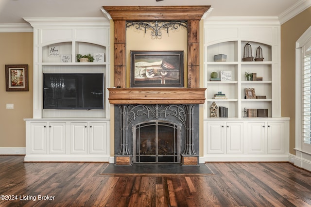 unfurnished living room with dark wood-style flooring, a fireplace with flush hearth, ornamental molding, baseboards, and built in shelves