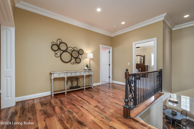 hallway with crown molding, wood finished floors, healthy amount of natural light, baseboards, and recessed lighting
