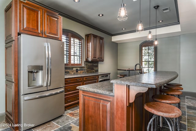kitchen featuring stainless steel fridge with ice dispenser, stone tile flooring, dark countertops, healthy amount of natural light, and crown molding