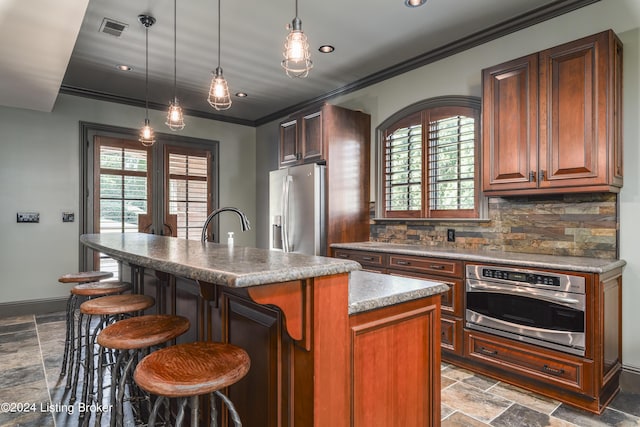 kitchen featuring stainless steel appliances, stone tile flooring, decorative backsplash, ornamental molding, and healthy amount of natural light