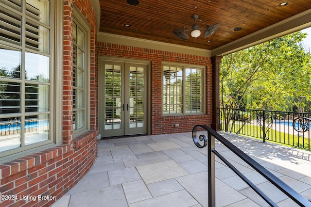 view of patio with french doors, fence, and a ceiling fan