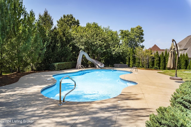 swimming pool featuring a water slide and a patio area