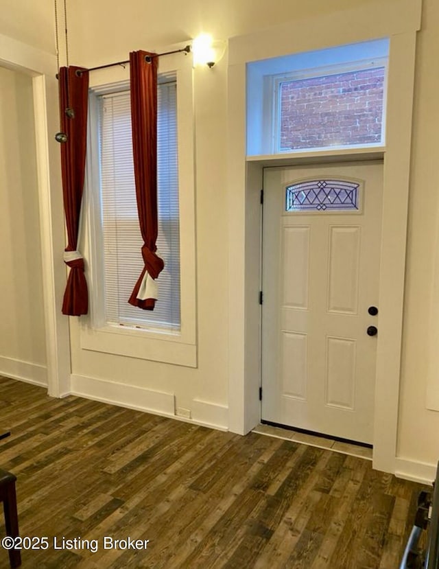 foyer entrance featuring dark wood finished floors and baseboards
