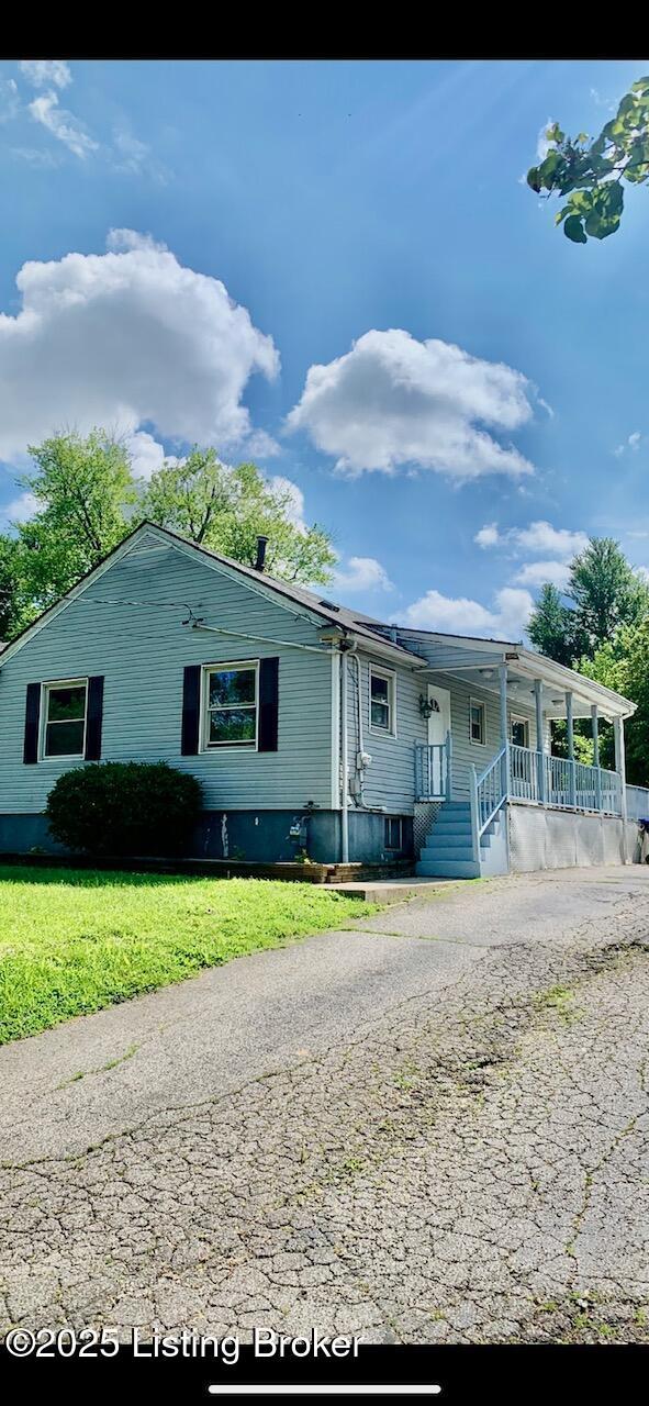 4727 Cliff Ave, Louisville, KY 40215 - view of front facade featuring covered porch, a front lawn, and asphalt driveway