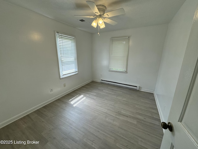 76 Bethel Church Rd, Brandenburg, KY 40108 - empty room featuring a baseboard heating unit, ceiling fan, wood finished floors, and baseboards