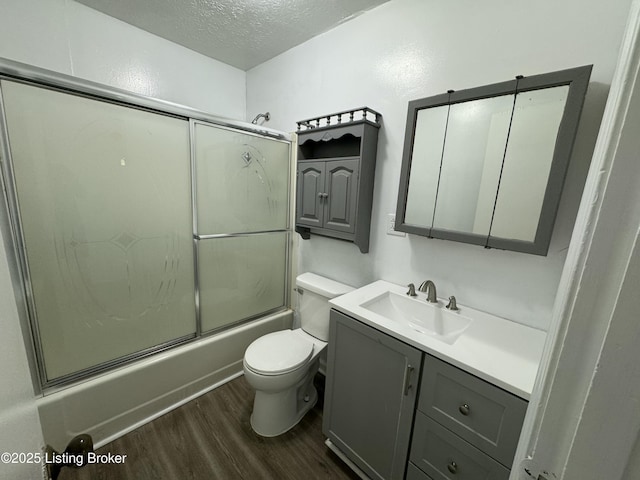 76 Bethel Church Rd, Brandenburg, KY 40108 - bathroom with a textured ceiling, wood finished floors, vanity, toilet, and shower / bath combination with glass door
