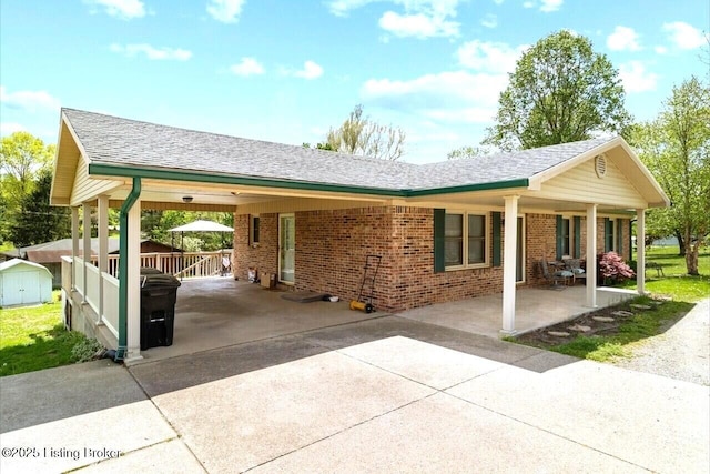 8887 New Haven Rd, New Haven, KY 40051 - view of front facade featuring driveway, brick siding, an attached carport, a storage unit, and a shingled roof
