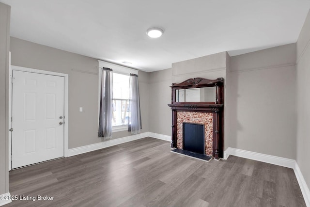 611 E Hill St, Louisville, KY 40217 - unfurnished living room featuring wood finished floors, a fireplace with flush hearth, and baseboards