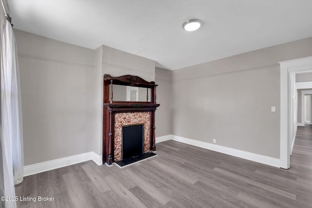 611 E Hill St, Louisville, KY 40217 - unfurnished living room with wood finished floors, baseboards, and a fireplace