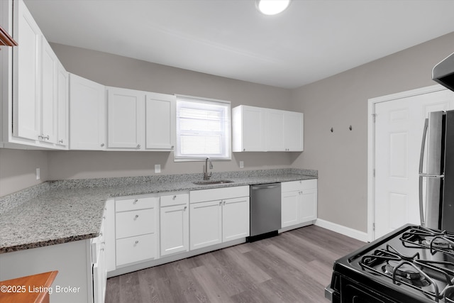 611 E Hill St, Louisville, KY 40217 - kitchen with gas stove, stainless steel dishwasher, a sink, refrigerator, and white cabinets