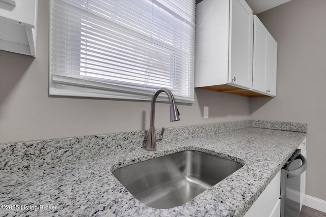 611 E Hill St, Louisville, KY 40217 - kitchen view of a sink, white cabinetry, light stone countertops, and dishwashing machine