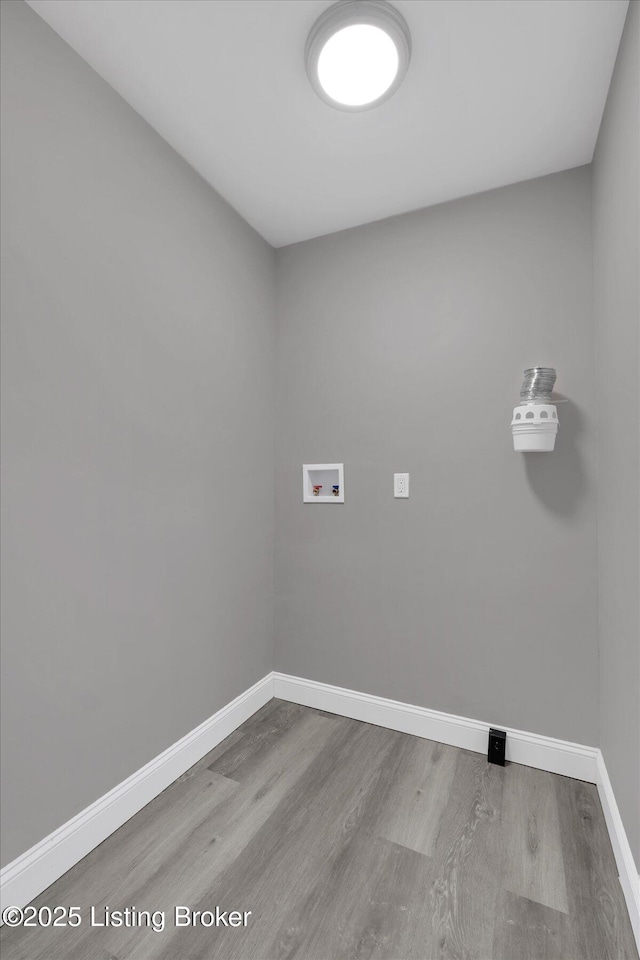 611 E Hill St, Louisville, KY 40217 - clothes washing area with washer hookup, wood finished floors, and baseboards