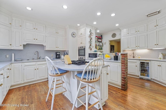 1802 Park Boundary Rd, Louisville, KY 40205 - kitchen with beverage cooler, a center island, white cabinets, crown molding, and light countertops