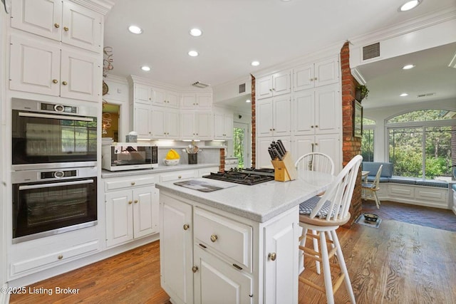 1802 Park Boundary Rd, Louisville, KY 40205 - kitchen featuring double oven, white cabinets, wood finished floors, light countertops, and ornamental molding