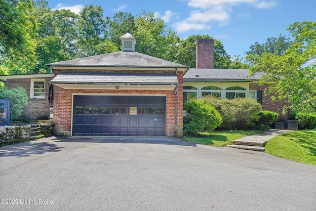 1802 Park Boundary Rd, Louisville, KY 40205 - view of front of home with asphalt driveway, a garage, a chimney, and brick siding
