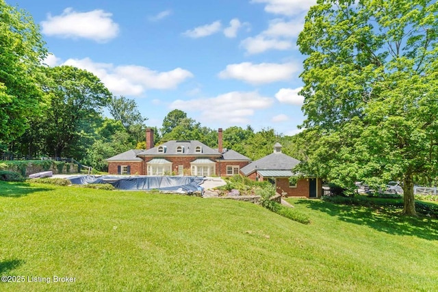 1802 Park Boundary Rd, Louisville, KY 40205 - rear view of house featuring a chimney, a lawn, brick siding, and a covered pool