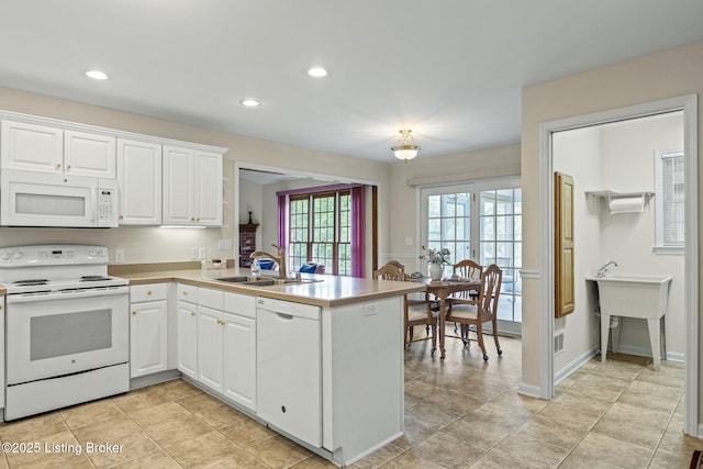 2434 Eastwood Cir, Crestwood, KY 40014 - kitchen with white appliances, a sink, a peninsula, white cabinets, and light countertops