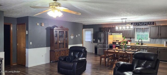 7 Dylan Ln, Upton, KY 42784 - living area featuring a textured ceiling, ceiling fan, dark wood finished floors, and a wainscoted wall