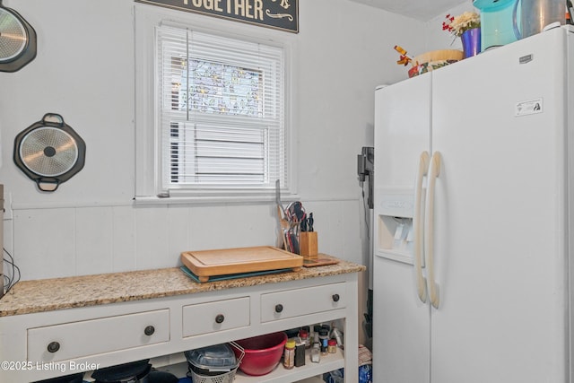 1412 Haskin Ave, Louisville, KY 40215 - kitchen with white fridge with ice dispenser, a wainscoted wall, and white cabinetry