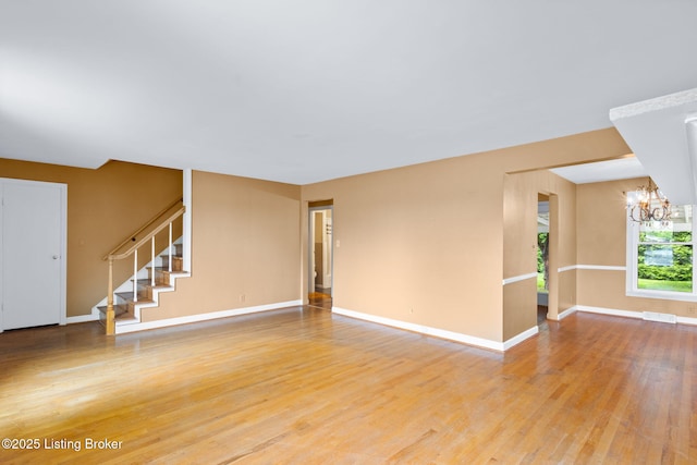 118 Guthrie Dr, Bardstown, KY 40004 - unfurnished living room with a chandelier, light wood finished floors, stairway, and baseboards