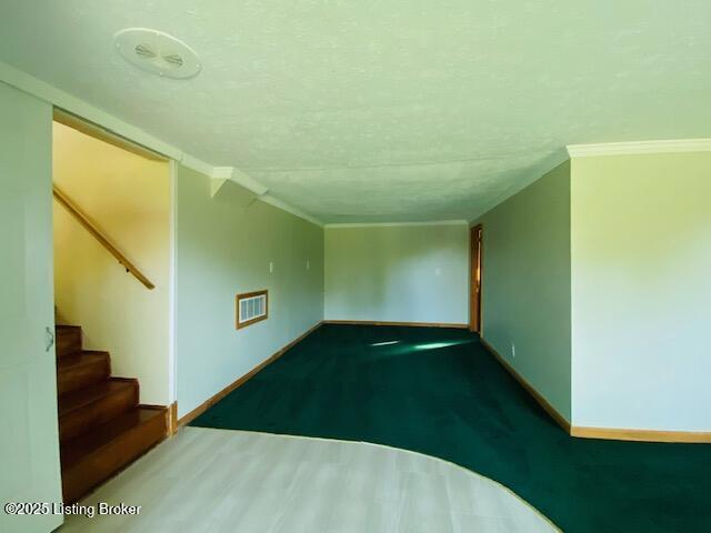 606 Nally Ct, Bardstown, KY 40004 - unfurnished living room with baseboards, ornamental molding, stairs, and a textured ceiling