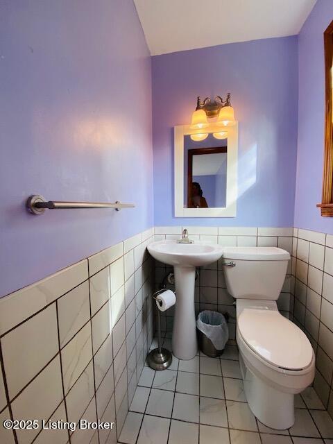 606 Nally Ct, Bardstown, KY 40004 - half bathroom with tile walls, toilet, tile patterned floors, a wainscoted wall, and a sink
