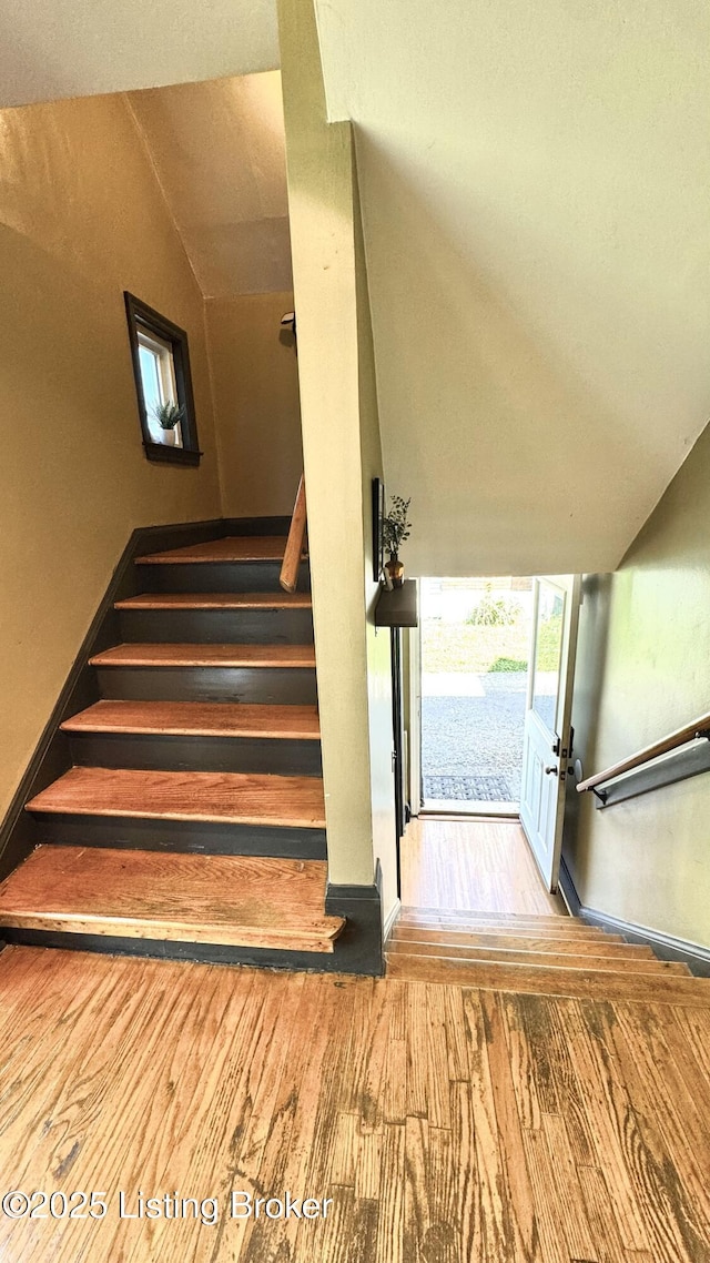 1239 Schiller Ave, Louisville, KY 40204 - stairs featuring wood finished floors, vaulted ceiling, and baseboards