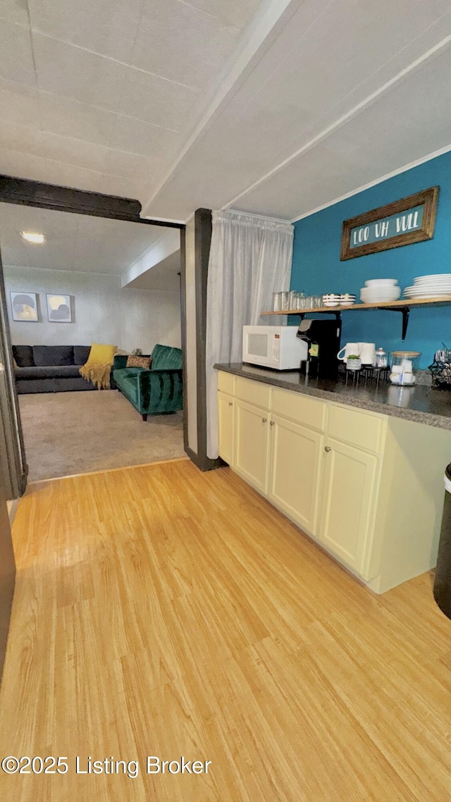 1239 Schiller Ave, Louisville, KY 40204 - kitchen with white microwave, light wood-type flooring, and dark countertops