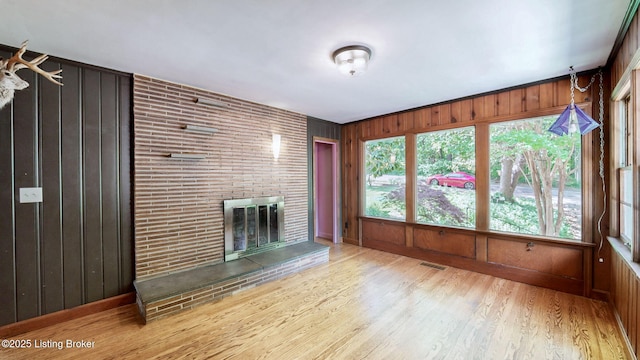 5303 Park Rd, Louisville, KY 40214 - unfurnished living room with wood finished floors, wooden walls, baseboards, and a brick fireplace