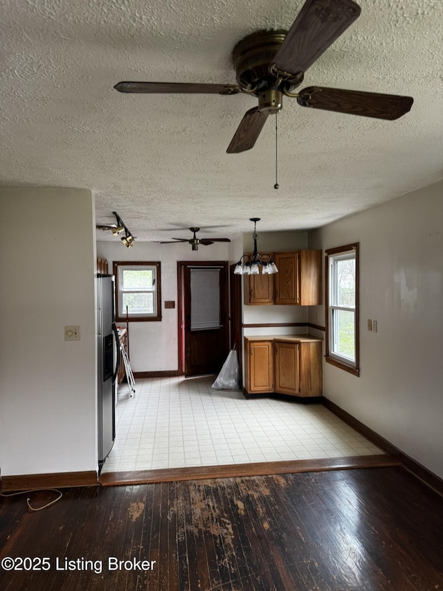 1614 Washington Blvd, Lyndon, KY 40242 - unfurnished living room with a ceiling fan, baseboards, light wood-style floors, healthy amount of natural light, and a textured ceiling