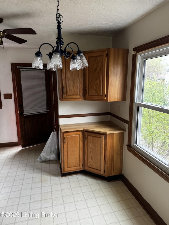 1614 Washington Blvd, Lyndon, KY 40242 - kitchen featuring a textured ceiling, brown cabinetry, ceiling fan, a chandelier, and baseboards