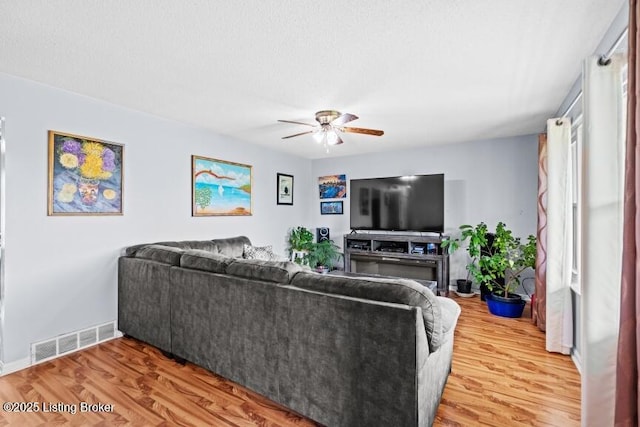 living room with a ceiling fan, wood finished floors, and baseboards