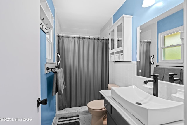 full bath featuring toilet, tile walls, a shower with curtain, tile patterned flooring, and vanity