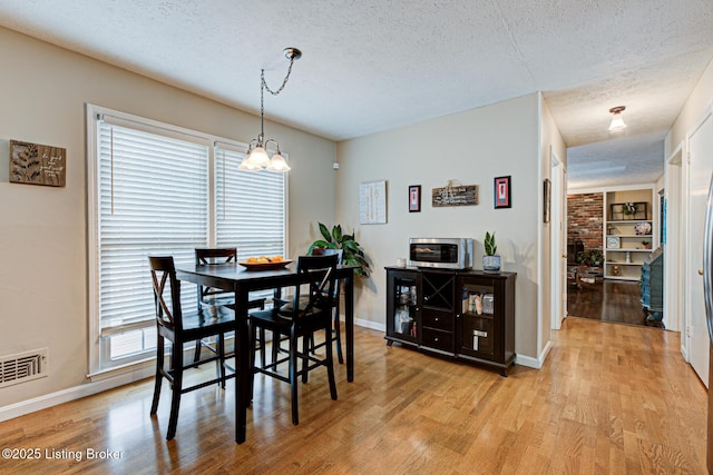 3904 Bayonne Ct, Jeffersontown, KY 40299 - dining space with light wood-type flooring, a textured ceiling, baseboards, and a chandelier