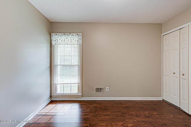 3904 Bayonne Ct, Jeffersontown, KY 40299 - unfurnished bedroom featuring hardwood / wood-style flooring, a closet, baseboards, and a textured ceiling
