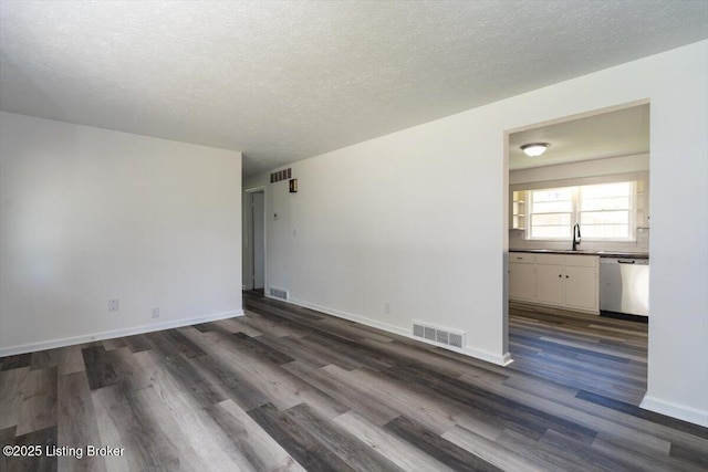6100 Jessamine Ln, Louisville, KY 40258 - spare room with dark wood finished floors, a textured ceiling, a sink, and baseboards