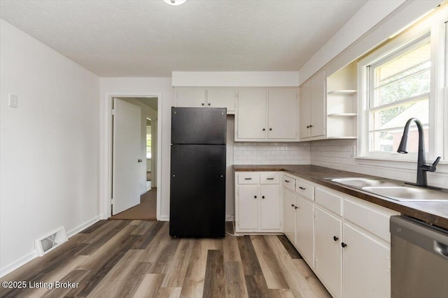 6100 Jessamine Ln, Louisville, KY 40258 - kitchen featuring freestanding refrigerator, stainless steel dishwasher, a sink, wood finished floors, and white cabinets