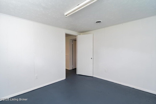 6100 Jessamine Ln, Louisville, KY 40258 - empty room with concrete flooring, a textured ceiling, and baseboards