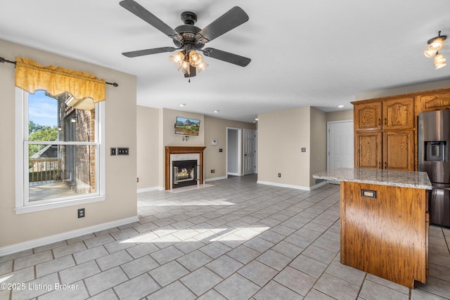 916 Winchester Blvd, Elizabethtown, KY 42701 - kitchen with stainless steel fridge with ice dispenser, baseboards, a fireplace, light tile patterned flooring, and ceiling fan