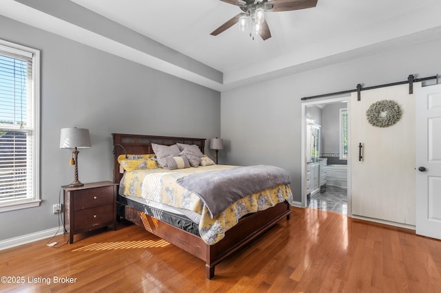 916 Winchester Blvd, Elizabethtown, KY 42701 - bedroom with wood finished floors, baseboards, a barn door, ensuite bathroom, and a ceiling fan