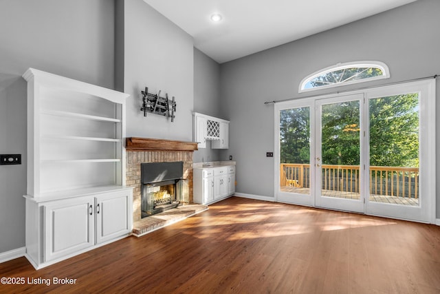 916 Winchester Blvd, Elizabethtown, KY 42701 - unfurnished living room with a brick fireplace, wood finished floors, baseboards, and a towering ceiling