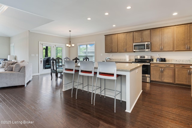 15905 Cabin View Ln, Louisville, KY 40245 - kitchen featuring appliances with stainless steel finishes, ornamental molding, dark wood finished floors, an island with sink, and a breakfast bar
