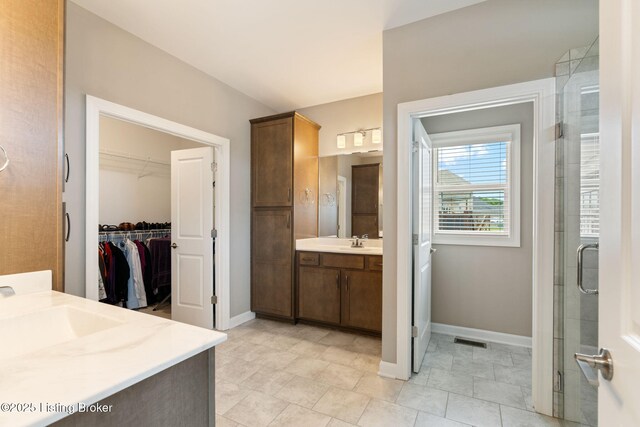15905 Cabin View Ln, Louisville, KY 40245 - bathroom featuring baseboards, a spacious closet, vanity, a stall shower, and tile patterned floors