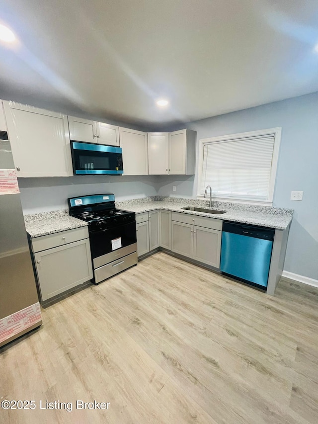 4302 Woodgate Ln, Louisville, KY 40220 - kitchen with appliances with stainless steel finishes, a sink, light wood finished floors, gray cabinets, and light stone countertops