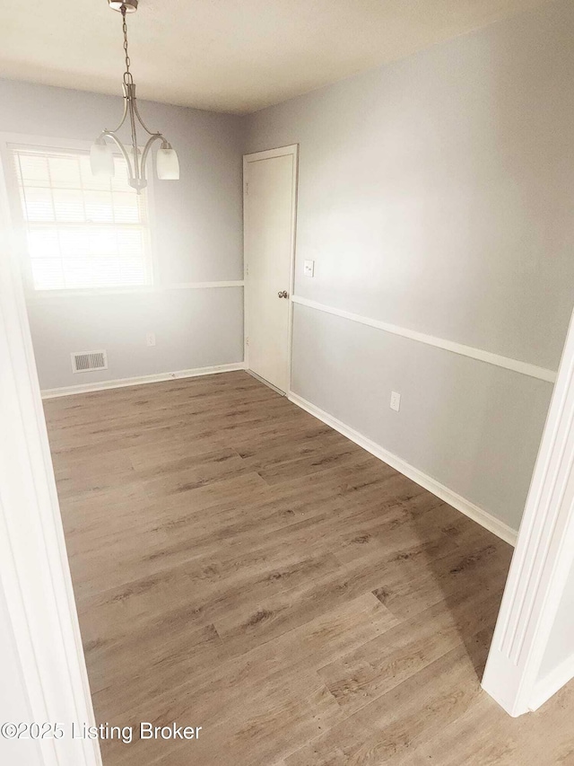 4302 Woodgate Ln, Louisville, KY 40220 - unfurnished dining area with a chandelier, wood finished floors, and baseboards