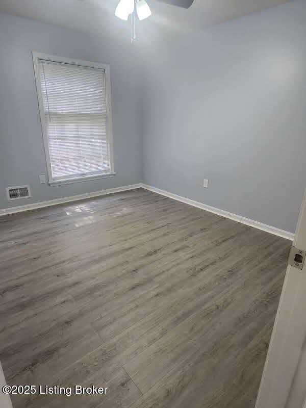 4302 Woodgate Ln, Louisville, KY 40220 - spare room with wood finished floors, baseboards, and a ceiling fan
