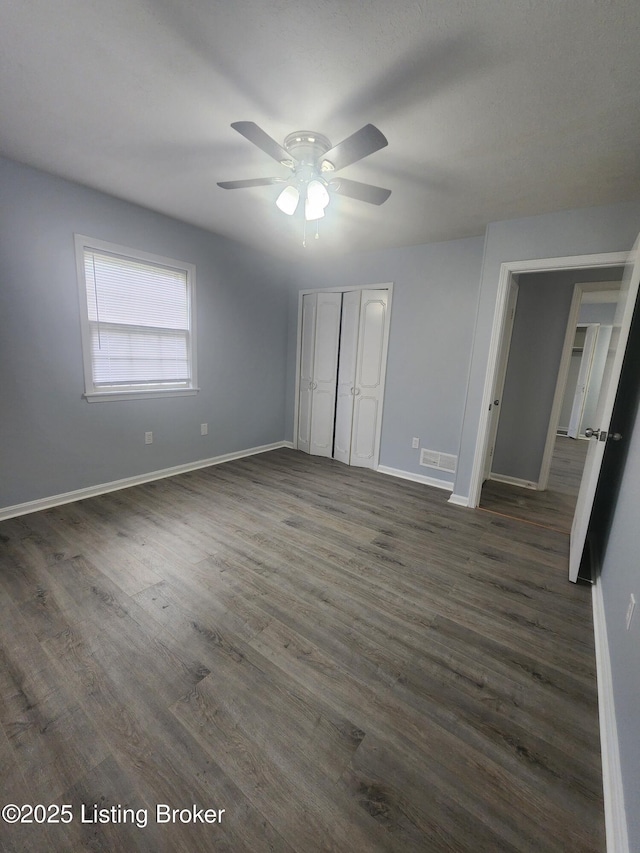 4302 Woodgate Ln, Louisville, KY 40220 - unfurnished bedroom with baseboards, dark wood-type flooring, a closet, and ceiling fan