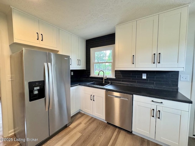 4813 Fox Chase Dr, Shepherdsville, KY 40165 - kitchen with stainless steel appliances, a sink, light wood-type flooring, dark countertops, and a textured ceiling