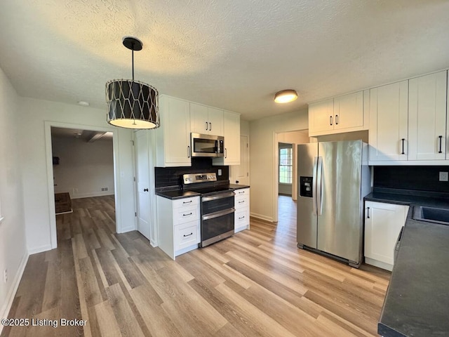 4813 Fox Chase Dr, Shepherdsville, KY 40165 - kitchen featuring stainless steel appliances, white cabinets, light wood-type flooring, dark countertops, and baseboards