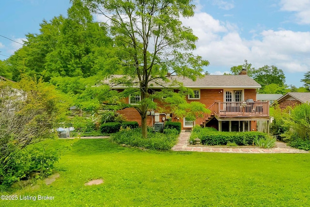 back of house featuring brick siding, stairs, a lawn, and a chimney